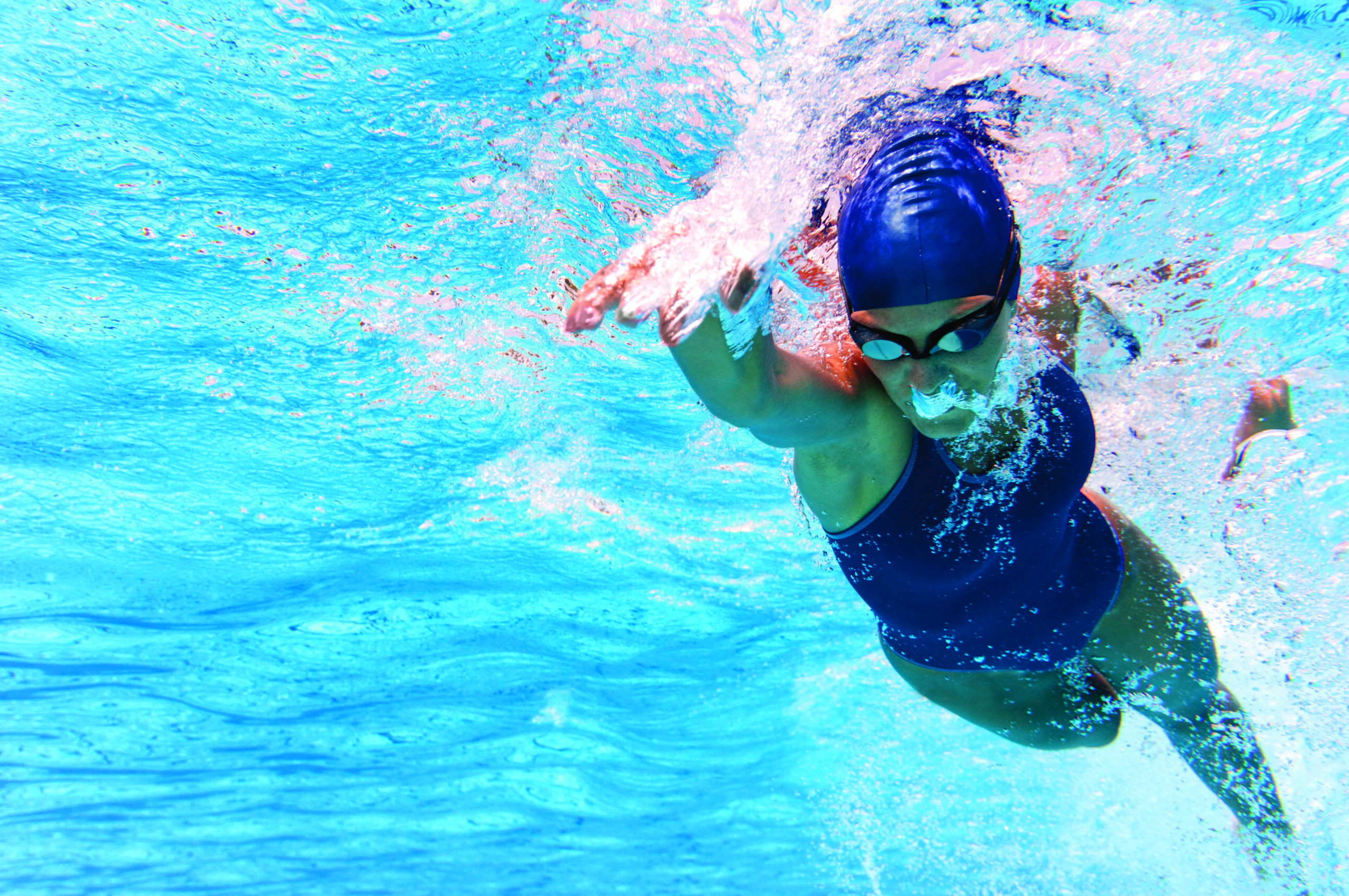 Underwater photo of female lap swimmer swimming freestyle.